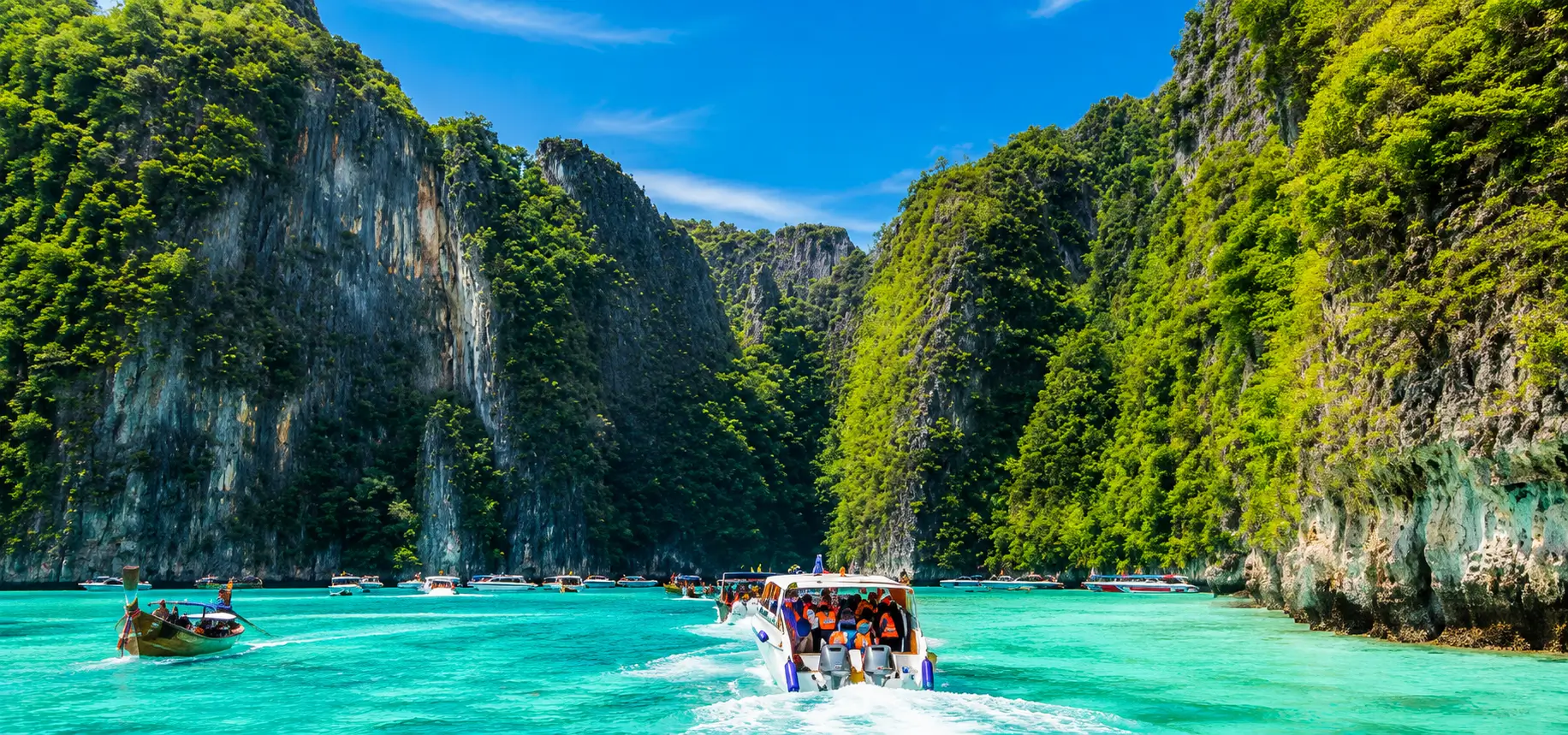 Tropical bay with boats and cliffs