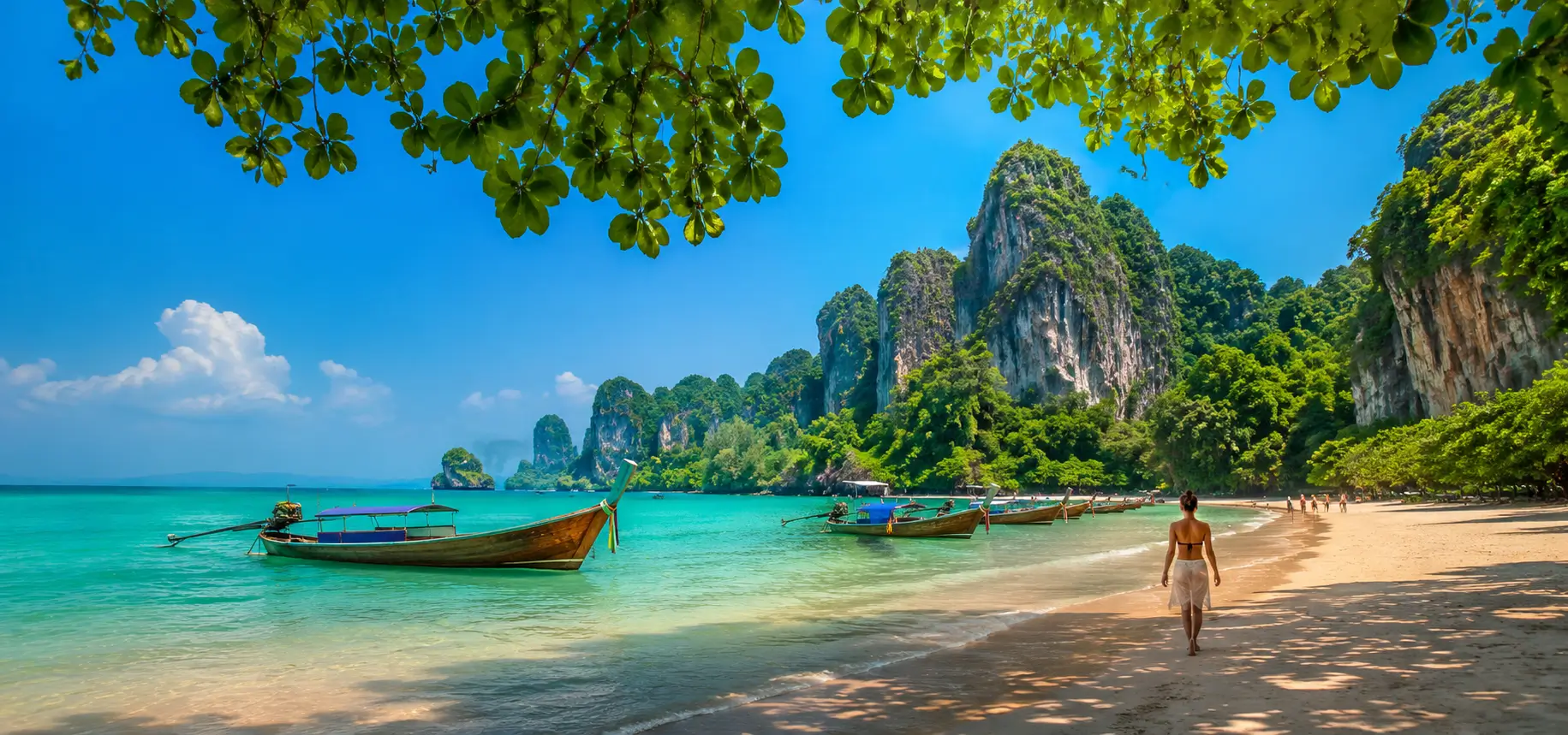 Tropical beach with boats and cliffs